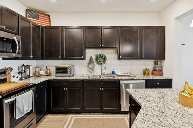 a kitchen with stainless steel appliances wooden cabinets and a sink