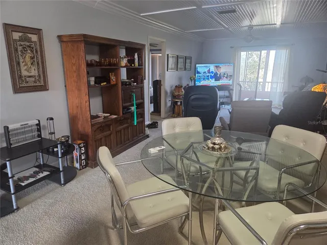a living room with furniture a dining table and window