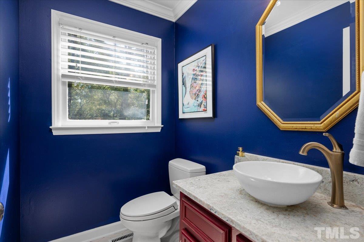 5116 Hallmark Road Durham, NC 27712 - Photo 14 of 31 a bathroom with a toilet a sink and mirror