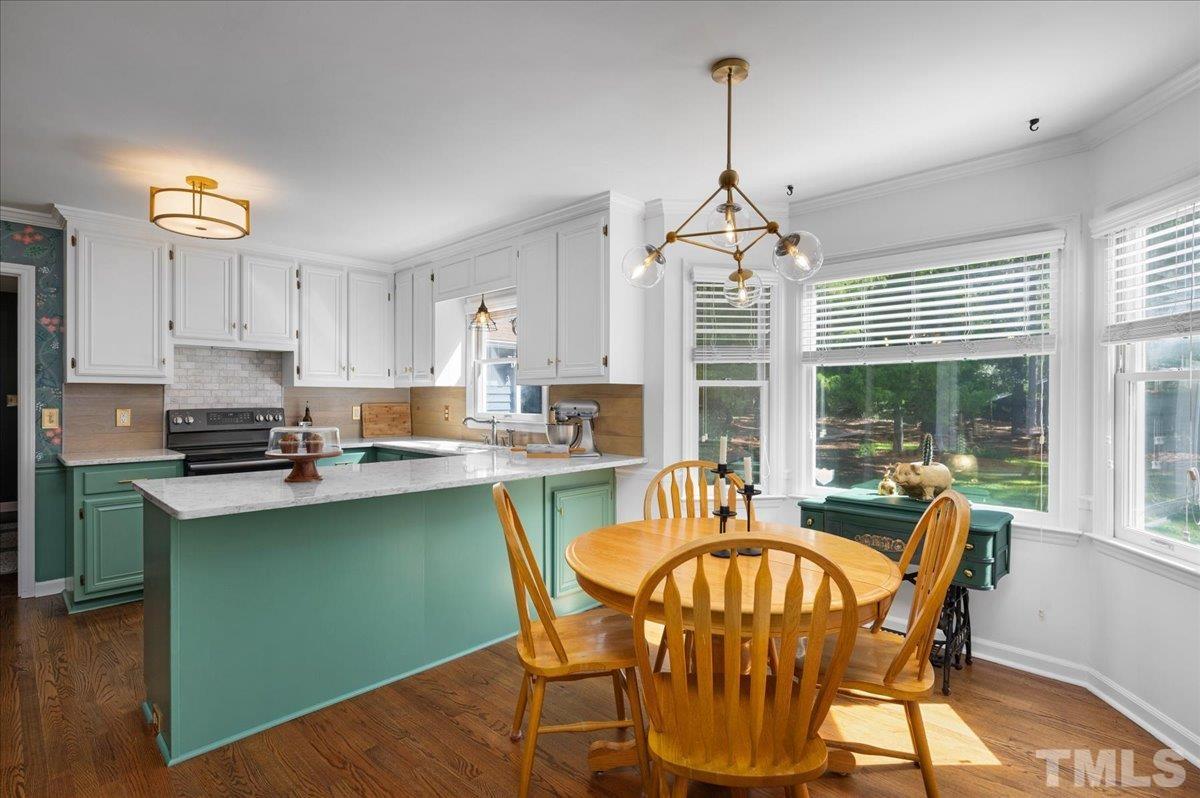 5116 Hallmark Road Durham, NC 27712 - Photo 15 of 31 a dining room with furniture a chandelier and wooden floor