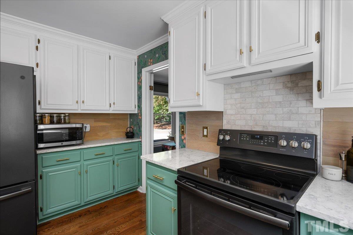 5116 Hallmark Road Durham, NC 27712 - Photo 16 of 31 a kitchen with kitchen island a sink stove and cabinets