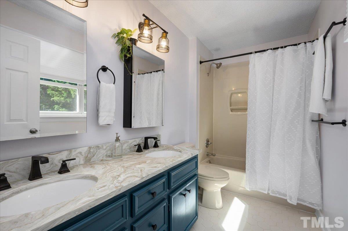 5116 Hallmark Road Durham, NC 27712 - Photo 21 of 31 a bathroom with a granite countertop sink toilet and shower