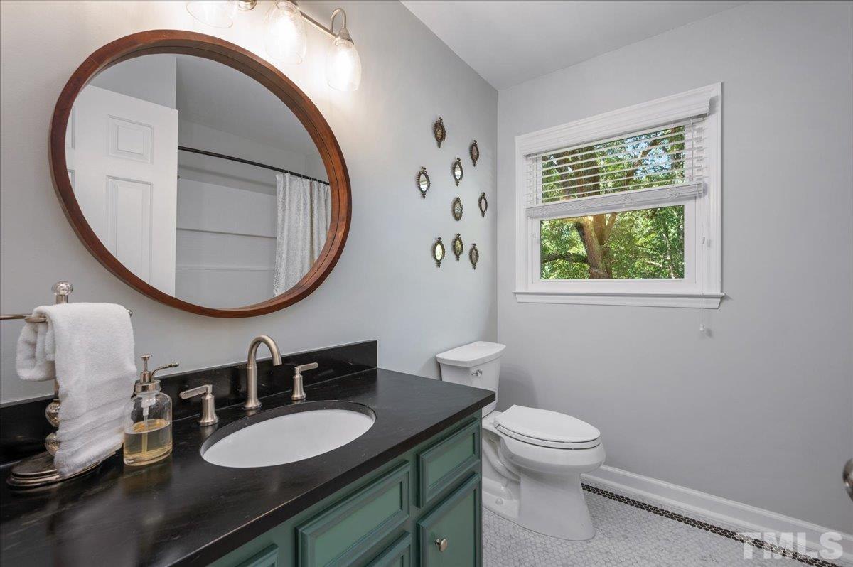 5116 Hallmark Road Durham, NC 27712 - Photo 25 of 31 a bathroom with a toilet a sink and mirror