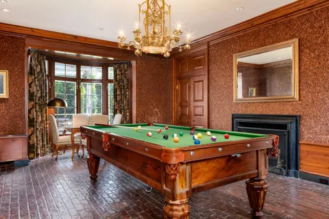 a room with pool table windows and wooden floor