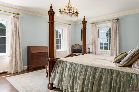 a bedroom with a bed and a dresser next to a window