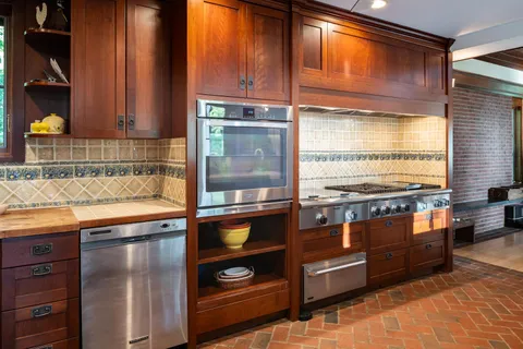 a kitchen with stainless steel appliances granite countertop a stove a sink and a microwave
