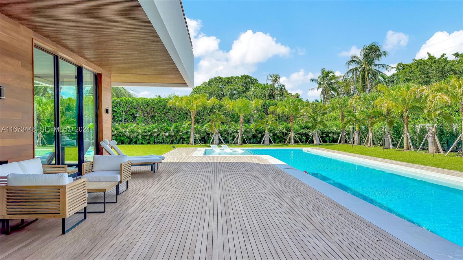 9860 Northeast 5th Avenue Road Miami Shores, FL 33138 - Photo 13 of 56 a view of swimming pool with seating space and trees in the background