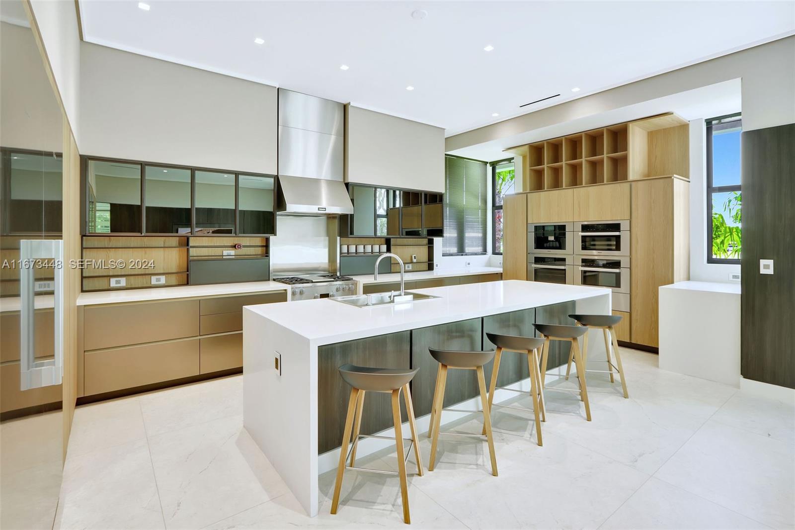 9860 Northeast 5th Avenue Road Miami Shores, FL 33138 - Photo 24 of 56 a kitchen with a sink and chairs