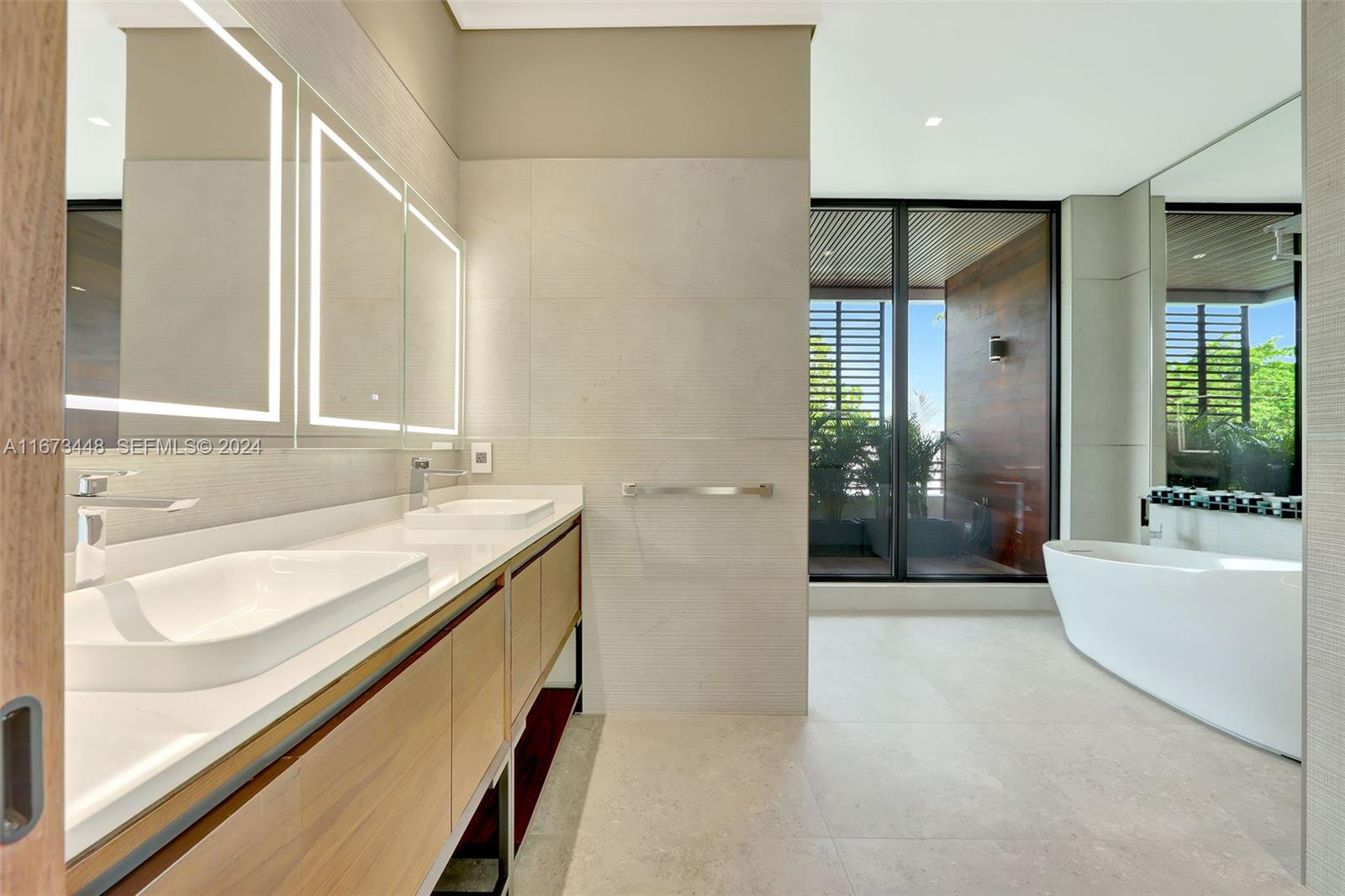 9860 Northeast 5th Avenue Road Miami Shores, FL 33138 - Photo 36 of 56 a bathroom with a granite countertop sink a toilet a mirror and shower