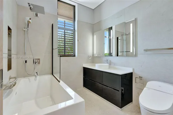 a bathroom with a granite countertop sink a toilet and a mirror