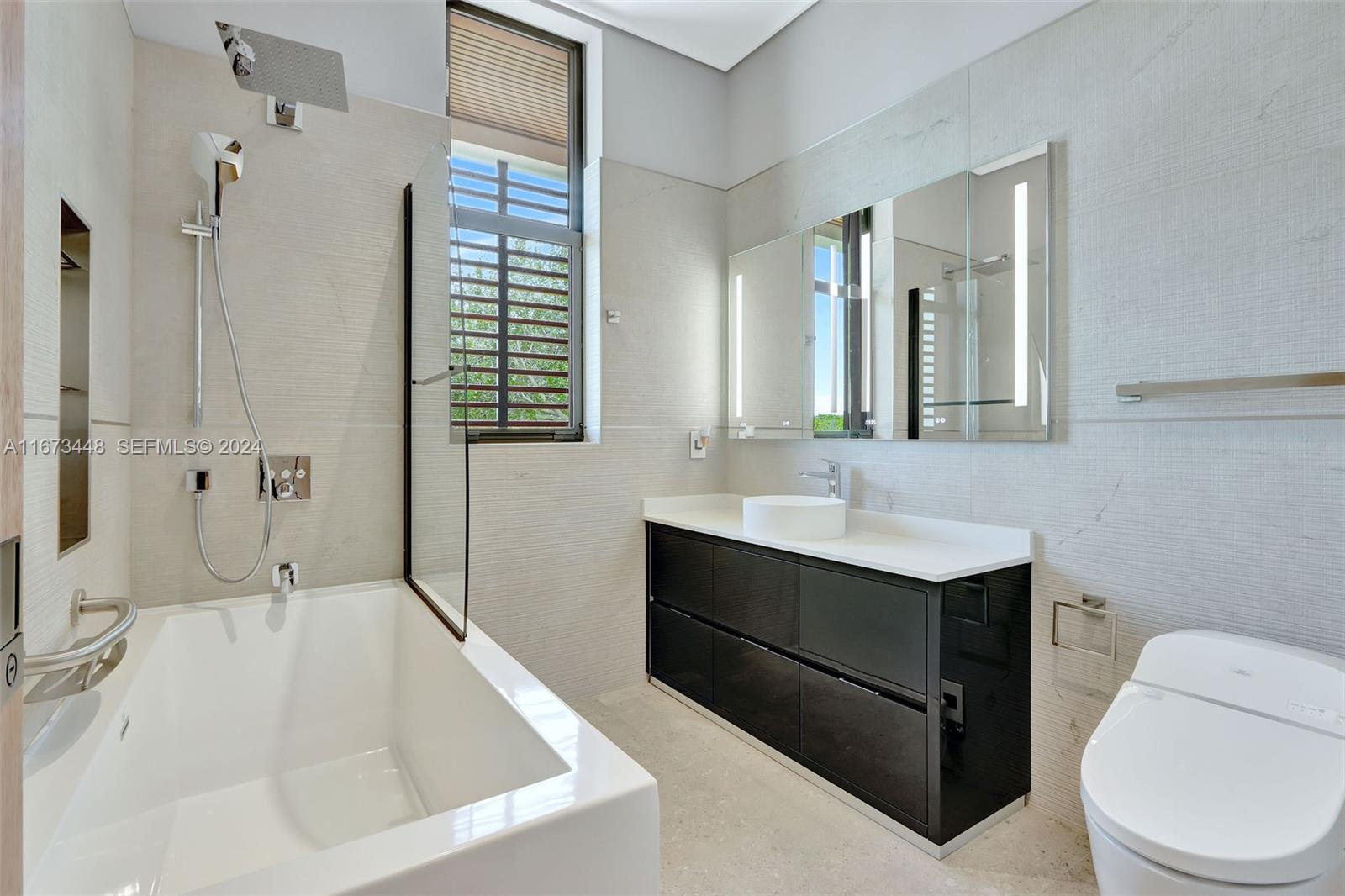 9860 Northeast 5th Avenue Road Miami Shores, FL 33138 - Photo 50 of 56 a bathroom with a tub sink and mirror