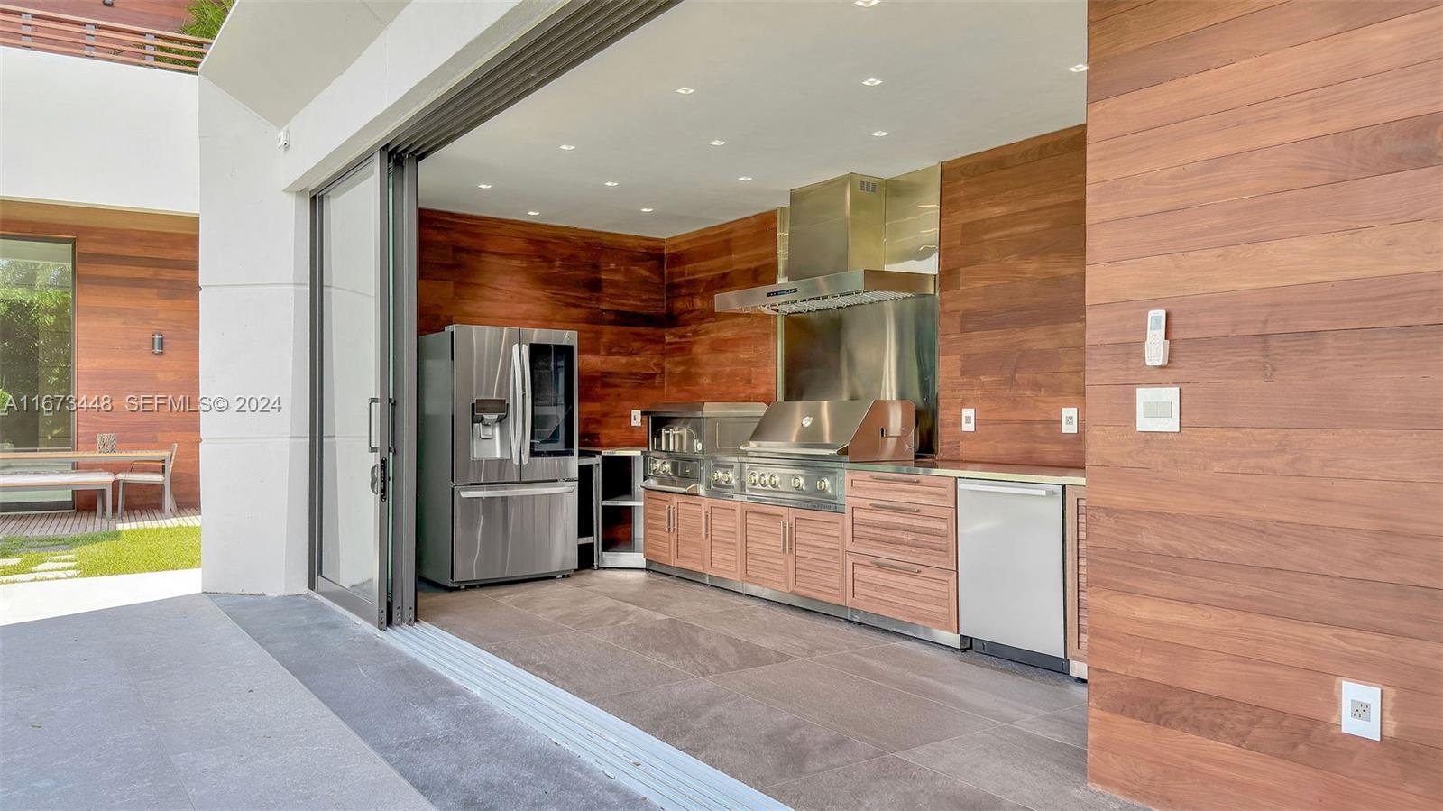 9860 Northeast 5th Avenue Road Miami Shores, FL 33138 - Photo 10 of 56 a kitchen with stainless steel appliances kitchen island granite countertop a refrigerator and a stove top oven