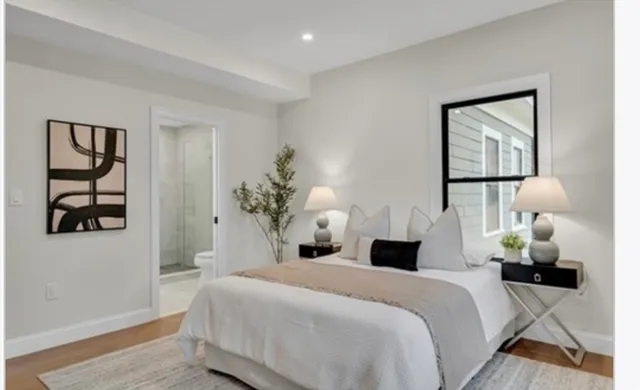 a bedroom with a bed and a painting on the wall