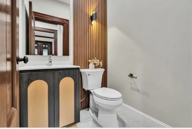 a bathroom with a granite countertop toilet sink and mirror
