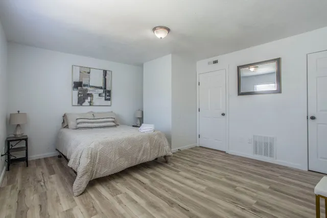 a bedroom with a bed and wooden floor
