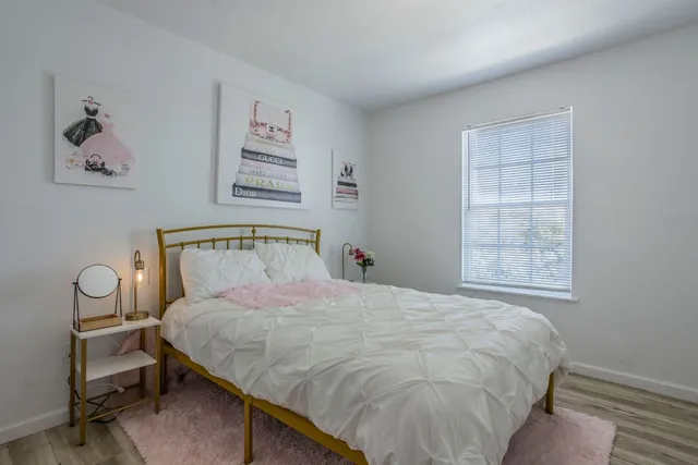 a large bed sitting in a bedroom next to a window