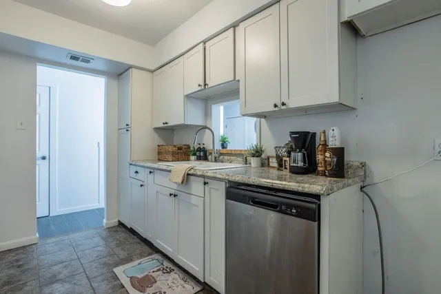 a kitchen with cabinets appliances a sink and a counter top space