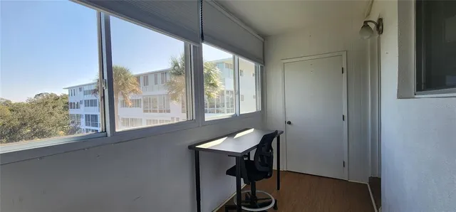 a view of a workspace with furniture and a window