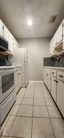 a kitchen with granite countertop a stove a sink and a microwave