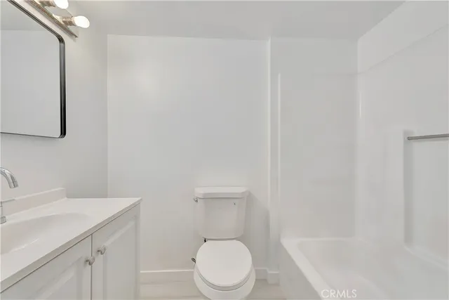 a white toilet sitting next to a bathroom sink