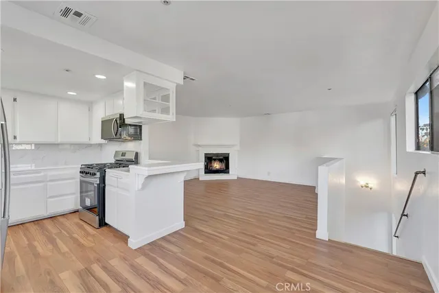 a kitchen with stainless steel appliances a white stove top oven a sink dishwasher and a refrigerator