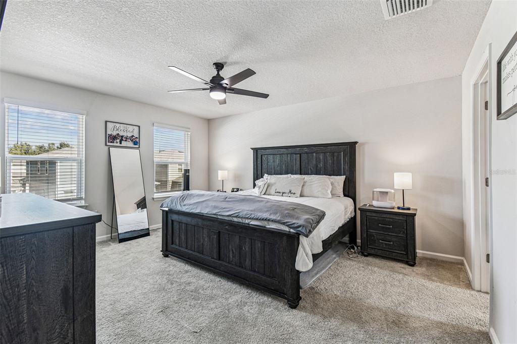 19043 Pebble Wood Ln Spring Hill Spring Hill, FL 34610 - Photo 18 of 35 a bedroom with a bed and a chandelier