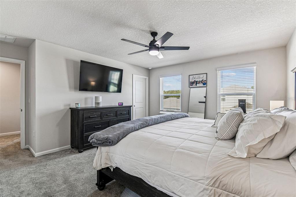 19043 Pebble Wood Ln Spring Hill Spring Hill, FL 34610 - Photo 20 of 35 a bedroom with a bed and a flat screen tv