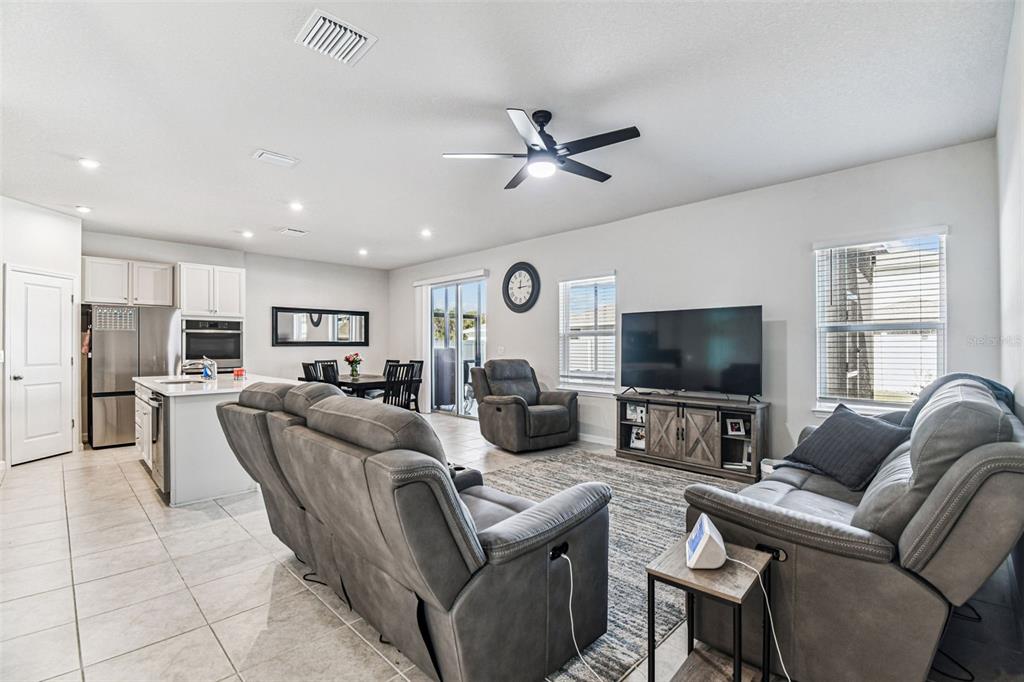 19043 Pebble Wood Ln Spring Hill Spring Hill, FL 34610 - Photo 5 of 35 a living room with furniture a ceiling fan and a flat screen tv