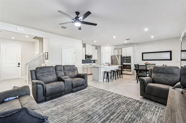 a living room with furniture and a view of kitchen