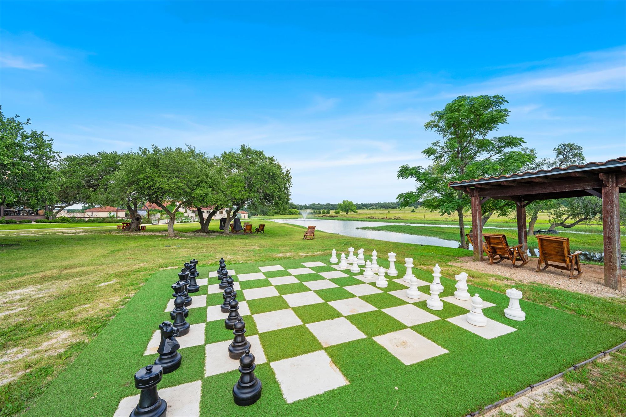 638 Strada Luca Florence, TX 76527 - Photo 38 of 38 An oversized chess set awaits on a verdant lawn, beside a tranquil pond and shaded patio.