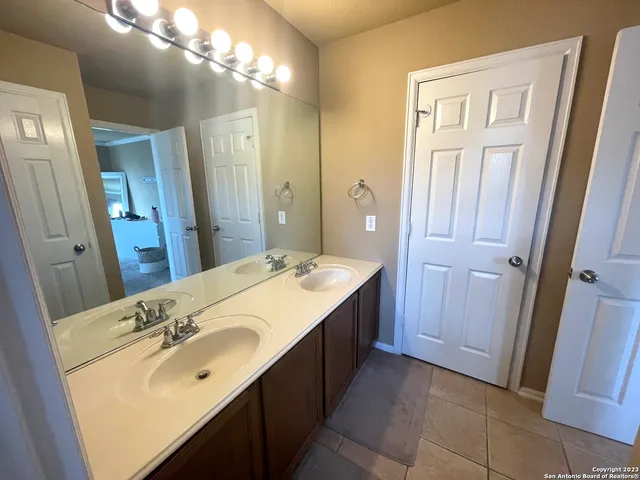 a bathroom with a double vanity sink and a mirror