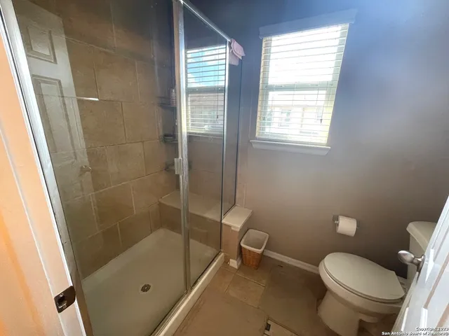 a white toilet sitting next to a bath tub