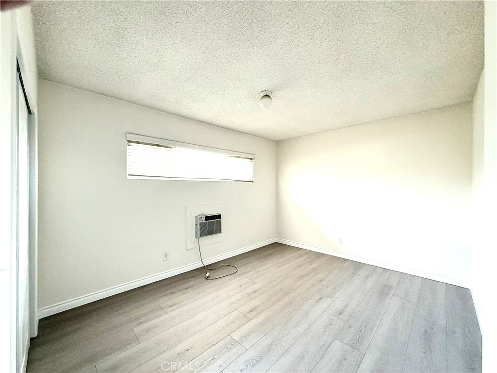 489 West Alpine Street, Unit F Upland, CA 91786 - Photo 11 of 12 an empty room with wooden floor and windows