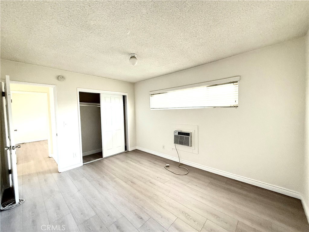 489 West Alpine Street, Unit F Upland, CA 91786 - Photo 12 of 12 an empty room with wooden floor and windows