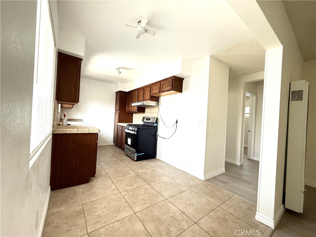 489 West Alpine Street, Unit F Upland, CA 91786 - Photo 3 of 12 a kitchen with a refrigerator and a flat screen tv
