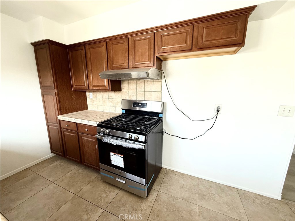 489 West Alpine Street, Unit F Upland, CA 91786 - Photo 6 of 12 a kitchen with stainless steel appliances granite countertop a stove and a refrigerator