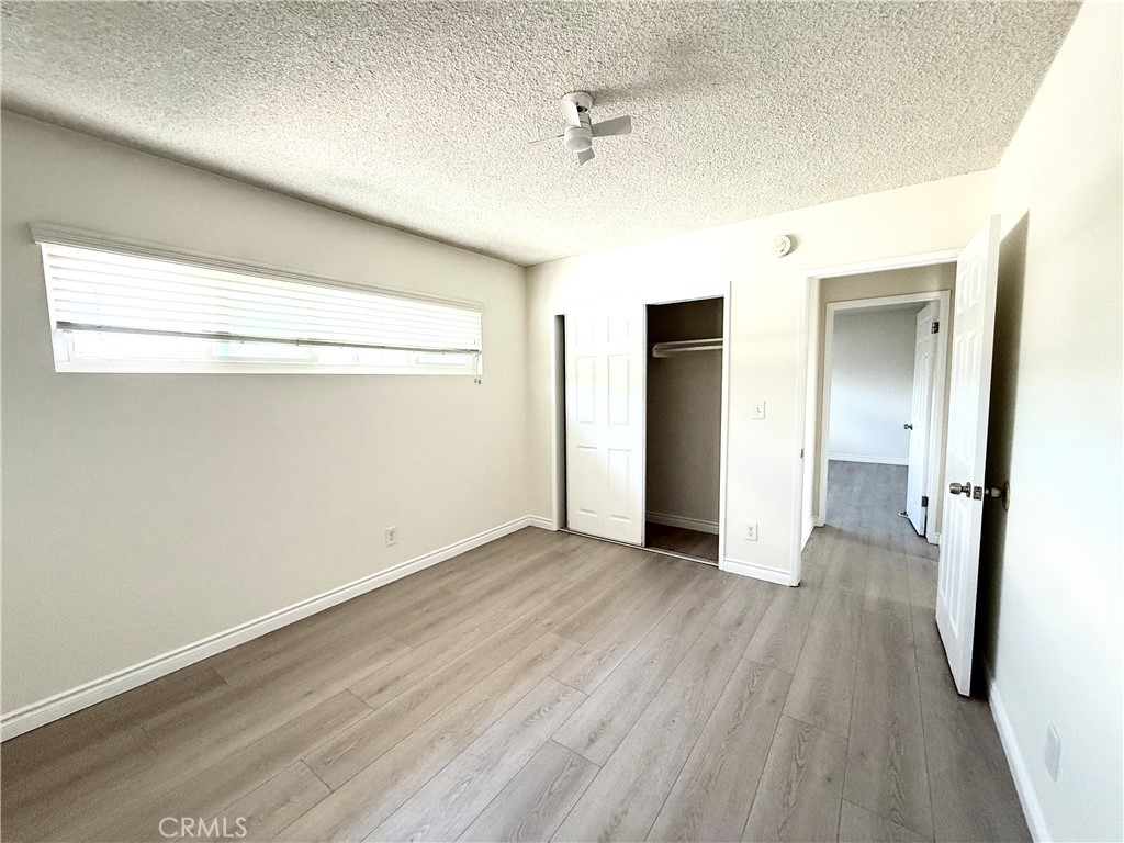 489 West Alpine Street, Unit F Upland, CA 91786 - Photo 10 of 12 wooden floor in an empty room with a window