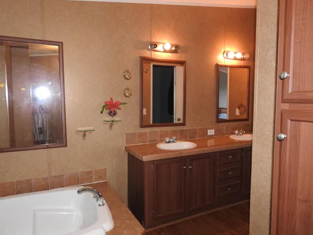 a spacious bathroom with a double vanity sink and a mirror