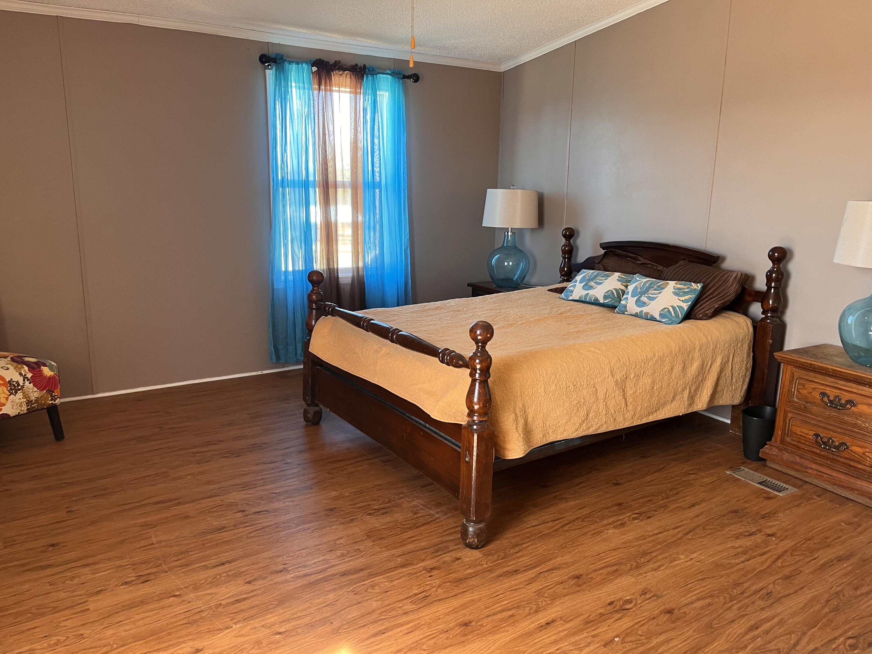 35 Rangeview Road Spur, TX 79370 - Photo 14 of 36 a bedroom with a bed and wooden floor