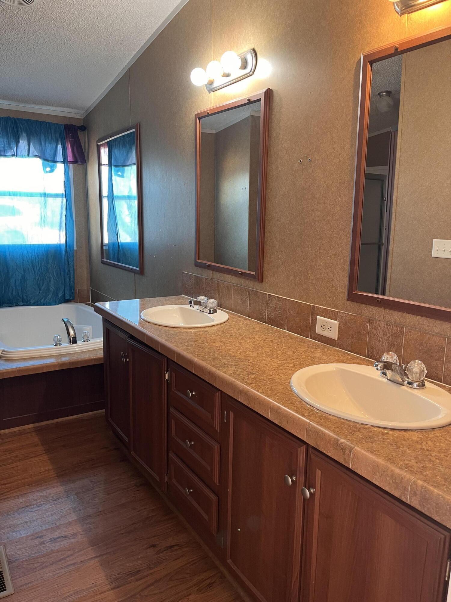 35 Rangeview Road Spur, TX 79370 - Photo 15 of 36 a bathroom with a sink double vanity granite tub and a mirror