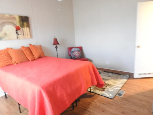 a large bed sitting in a bedroom next to a window and a mirror