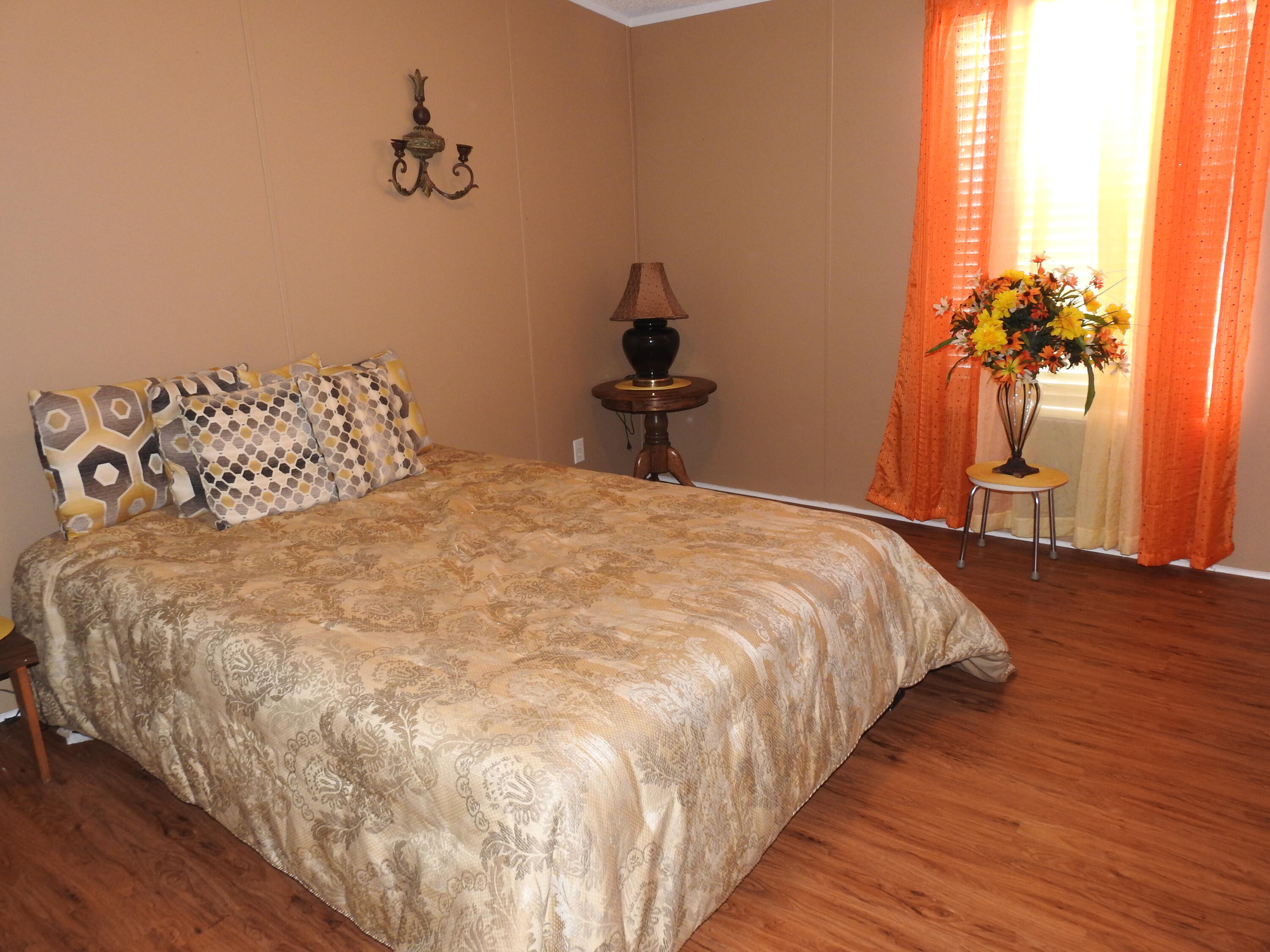 35 Rangeview Road Spur, TX 79370 - Photo 21 of 34 a large bed sitting in a bedroom next to a window and a mirror