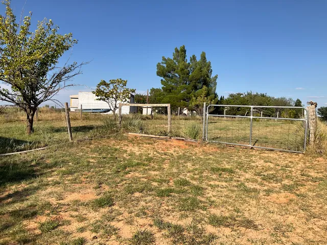 a view of a swimming pool with a yard from inside of house
