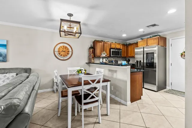 a dining hall with stainless steel appliances kitchen island granite countertop a table and chairs