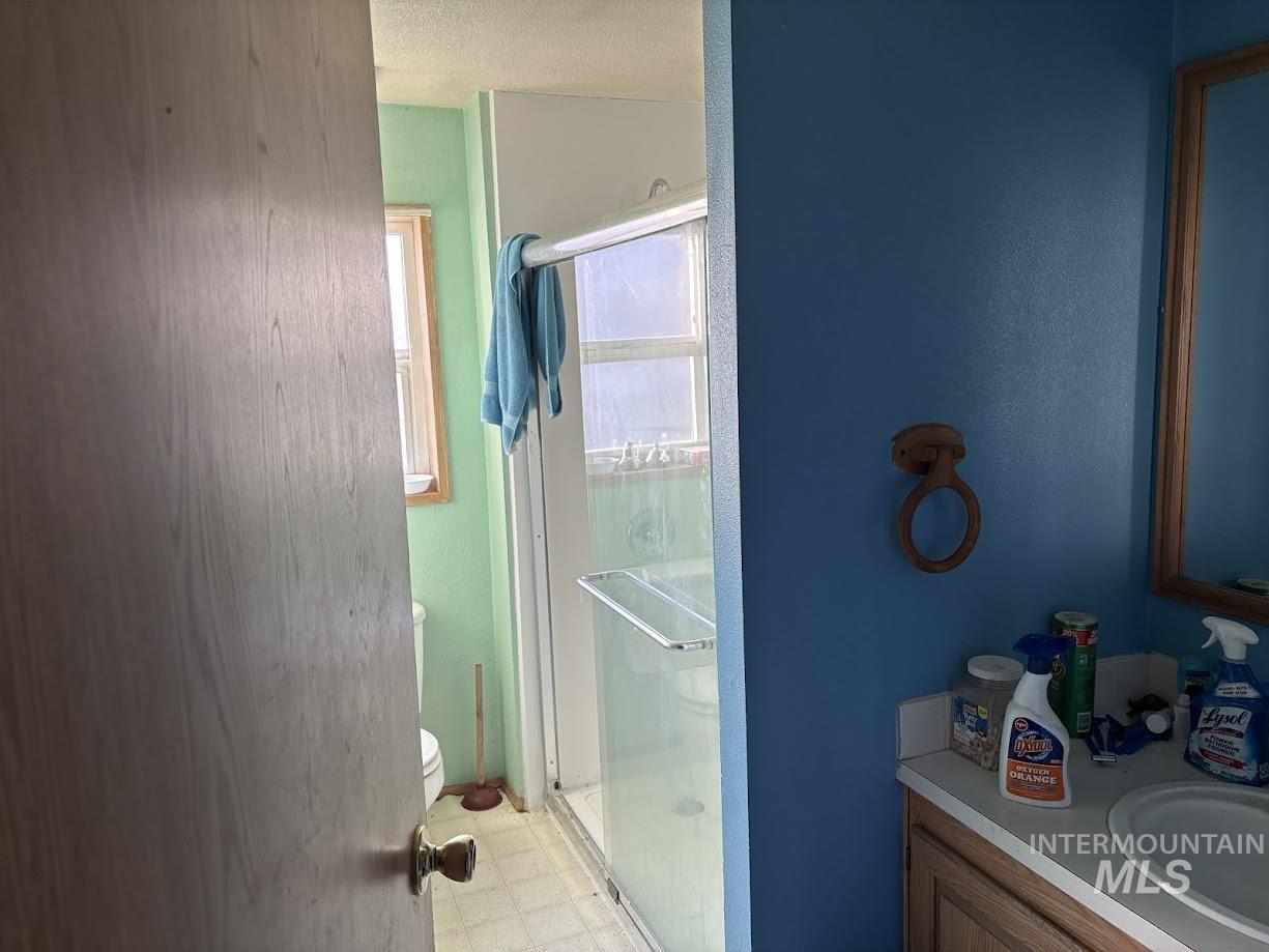 111 Throop Street Colfax, WA 99111 - Photo 8 of 10 Bathroom featuring vanity, a shower stall, light flooring, washer / clothes dryer, and a textured ceiling
