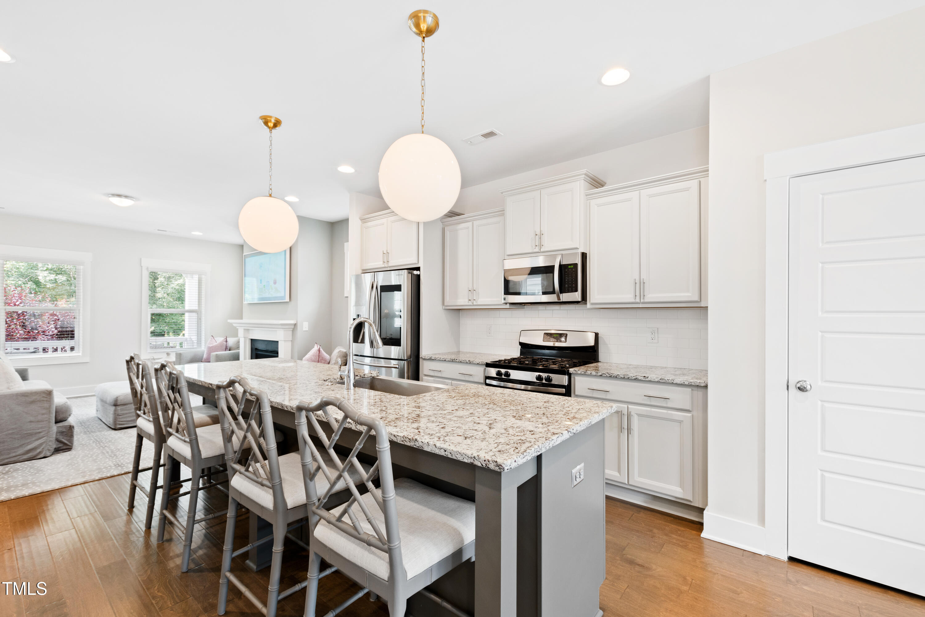 71 Hawk Point Road Chapel Hill, NC 27516 - Photo 9 of 35 a kitchen with stainless steel appliances granite countertop a stove a sink a dining table and chairs with wooden floor