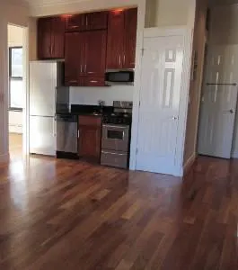 a kitchen with granite countertop wooden floors stainless steel appliances and cabinets