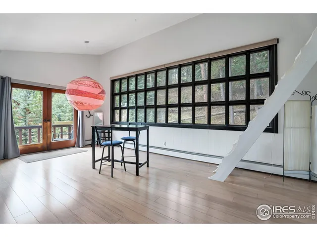 a living room with furniture wooden floor and floor to ceiling windows