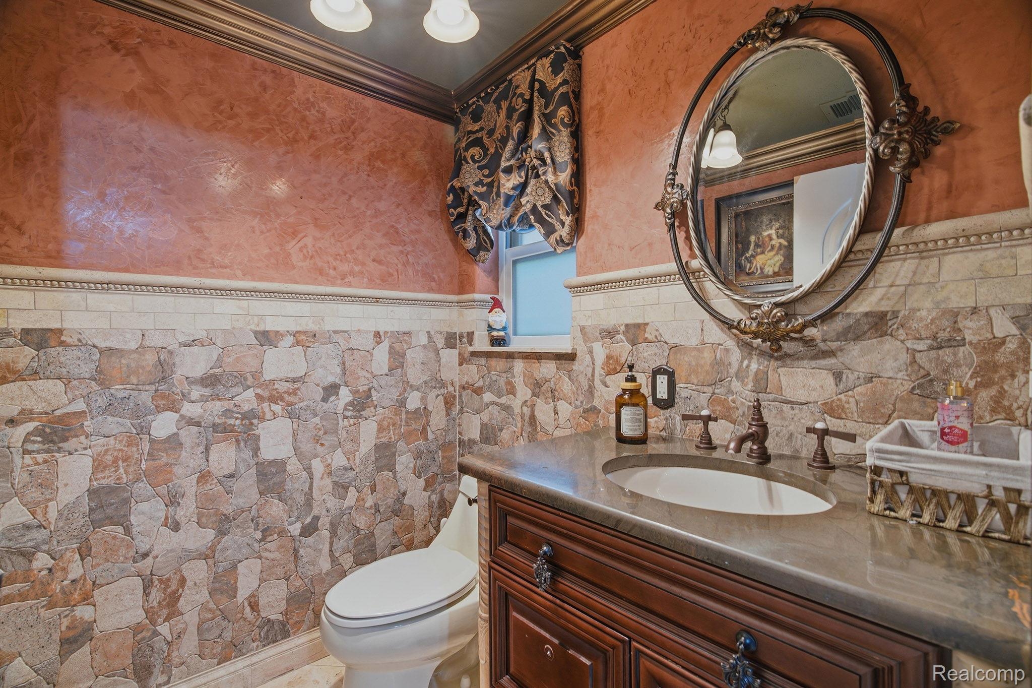1258 Priscilla Lane Rochester, MI 48309 - Photo 33 of 56 Vanity with integrated sink and dark countertop, complemented by a decorative framed mirror