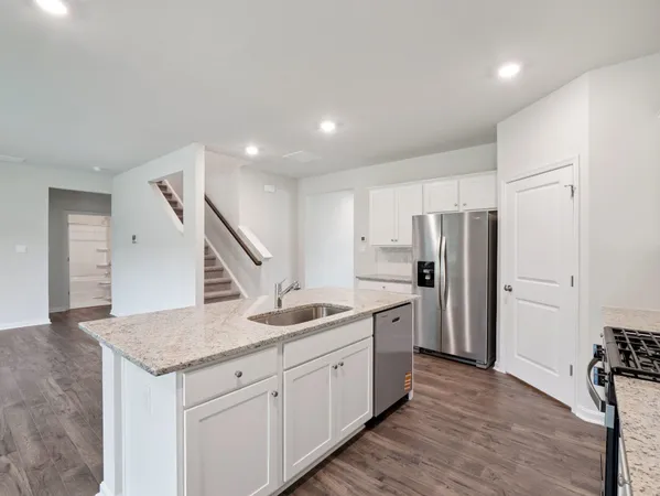 a kitchen with stainless steel appliances granite countertop a sink and a refrigerator